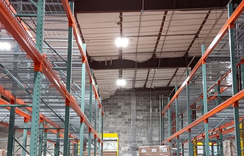Image of a warehouse with lighting on the rooftop.